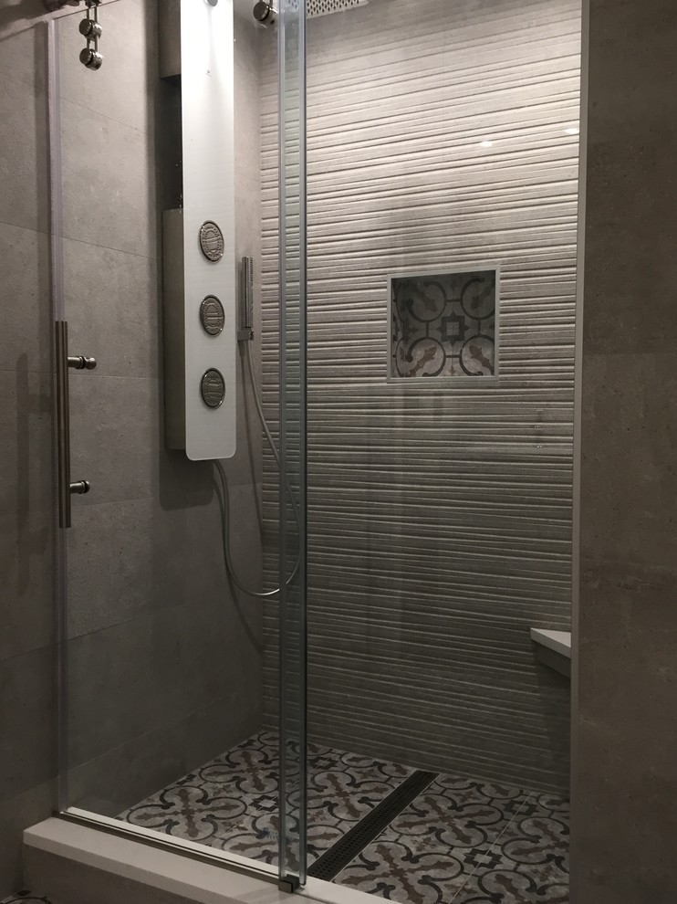 Bild på ett mellanstort funkis en-suite badrum, med släta luckor, en dusch i en alkov, en toalettstol med hel cisternkåpa, grå kakel, porslinskakel, ett undermonterad handfat, grå skåp, bruna väggar, linoleumgolv och bänkskiva i akrylsten