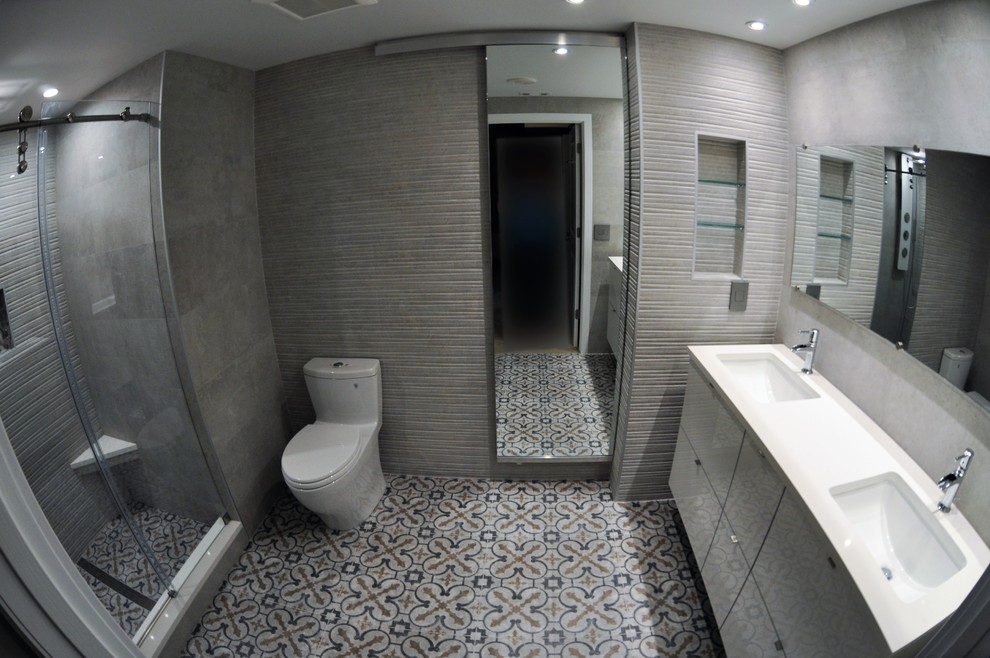 Bild på ett mellanstort funkis en-suite badrum, med släta luckor, grå skåp, en dusch i en alkov, en toalettstol med hel cisternkåpa, bruna väggar, linoleumgolv, ett undermonterad handfat och bänkskiva i akrylsten