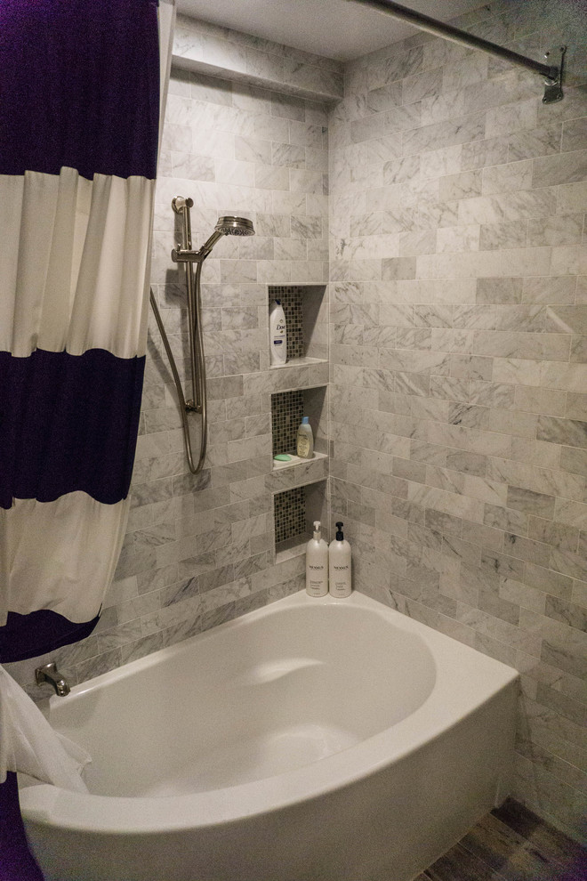Klassisk inredning av ett mellanstort badrum med dusch, med öppna hyllor, vita skåp, en toalettstol med hel cisternkåpa, klinkergolv i porslin, granitbänkskiva, ett hörnbadkar, en hörndusch, grå kakel, stenkakel, grå väggar och ett undermonterad handfat