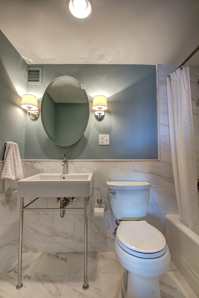 Exempel på ett litet klassiskt en-suite badrum, med ett konsol handfat, ett badkar i en alkov, en dusch/badkar-kombination, en toalettstol med separat cisternkåpa, vit kakel, porslinskakel, blå väggar och klinkergolv i porslin