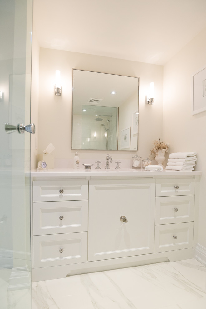 トロントにある小さなトラディショナルスタイルのおしゃれなバスルーム (浴槽なし) (白いキャビネット、白いタイル、磁器タイル、ベージュの壁、大理石の床、アンダーカウンター洗面器、クオーツストーンの洗面台) の写真