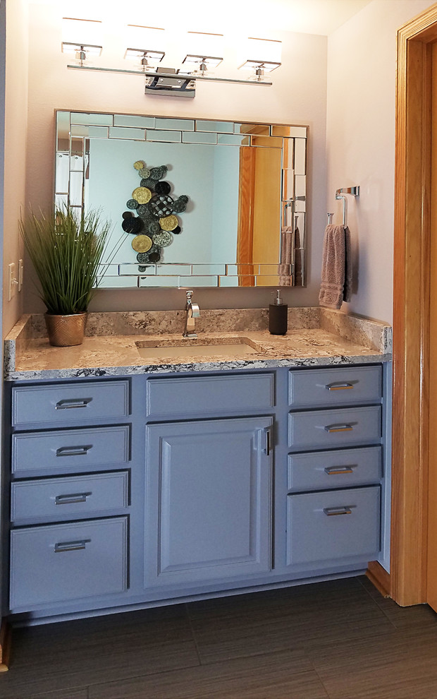 Inredning av ett klassiskt litet badrum med dusch, med luckor med upphöjd panel, en toalettstol med separat cisternkåpa, grå kakel, grå väggar, klinkergolv i porslin, ett undermonterad handfat, bänkskiva i kvarts och brunt golv
