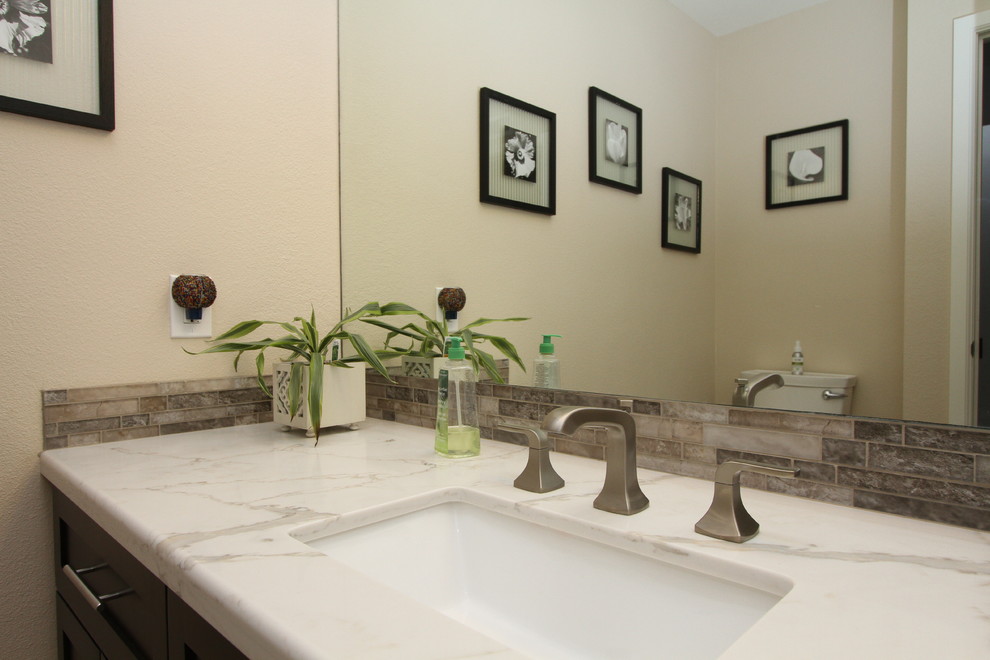 This is an example of a medium sized traditional shower room bathroom in Orange County with shaker cabinets, dark wood cabinets, an alcove shower, a two-piece toilet, grey tiles, porcelain tiles, beige walls, porcelain flooring, a submerged sink, engineered stone worktops, beige floors and a hinged door.