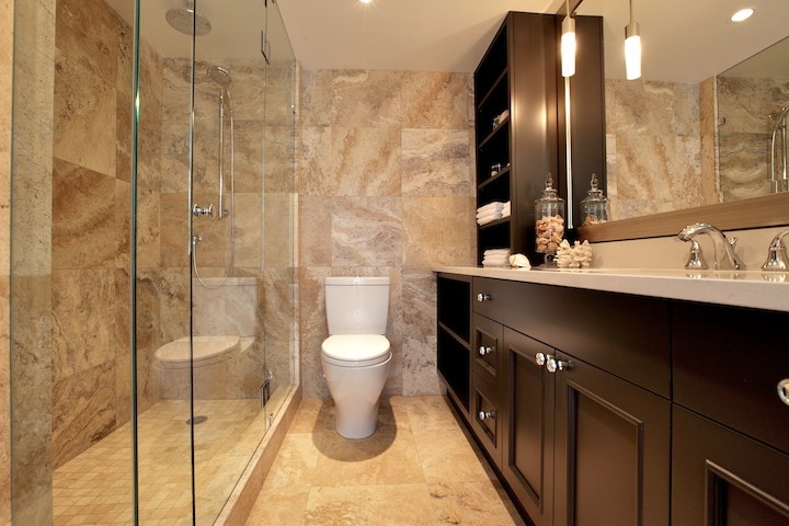 Inspiration for a small contemporary shower room bathroom in Vancouver with shaker cabinets, an alcove shower, beige tiles, stone tiles, a submerged sink, solid surface worktops, black cabinets, a two-piece toilet, beige walls and porcelain flooring.
