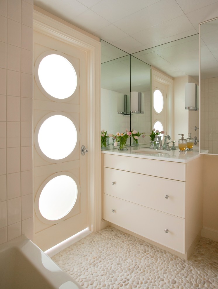 Aménagement d'une salle de bain moderne avec un lavabo encastré, un placard à porte plane, des portes de placard beiges, une plaque de galets et un sol en galet.
