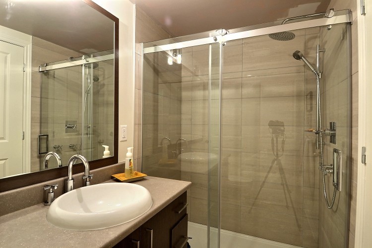 Immagine di una stanza da bagno eclettica con lavabo da incasso, ante lisce, ante in legno bruno, top in laminato, doccia alcova, WC monopezzo, piastrelle grigie e piastrelle in ceramica
