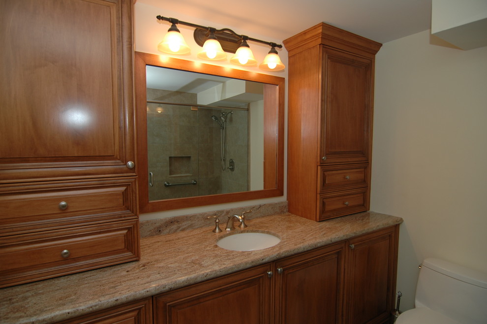 На фото: главная ванная комната в классическом стиле с фасадами с выступающей филенкой, унитазом-моноблоком, врезной раковиной и столешницей из гранита