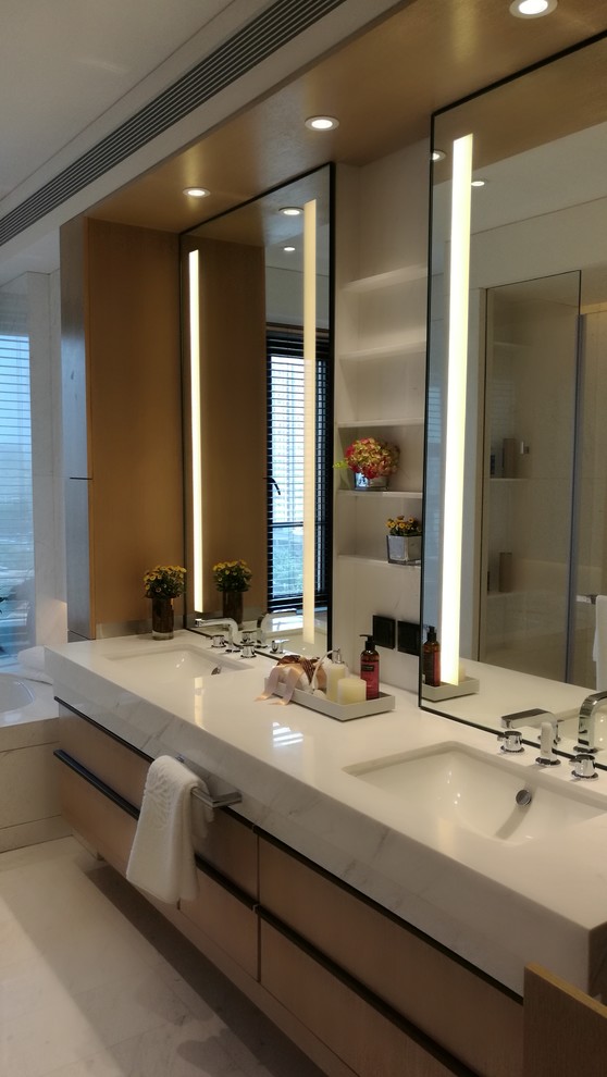 Esempio di una stanza da bagno padronale contemporanea di medie dimensioni con lavabo sottopiano, pavimento beige, ante lisce, ante in legno chiaro e top in marmo