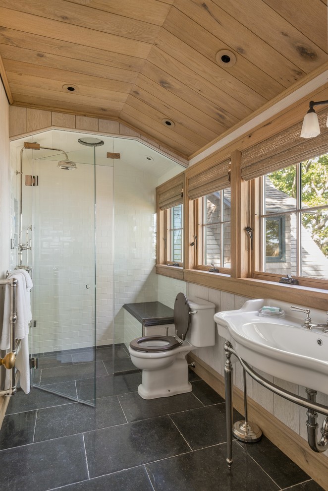 Example of a mountain style 3/4 ceramic tile and black floor alcove shower design in New York with marble countertops, a hinged shower door, a two-piece toilet, white walls and a console sink