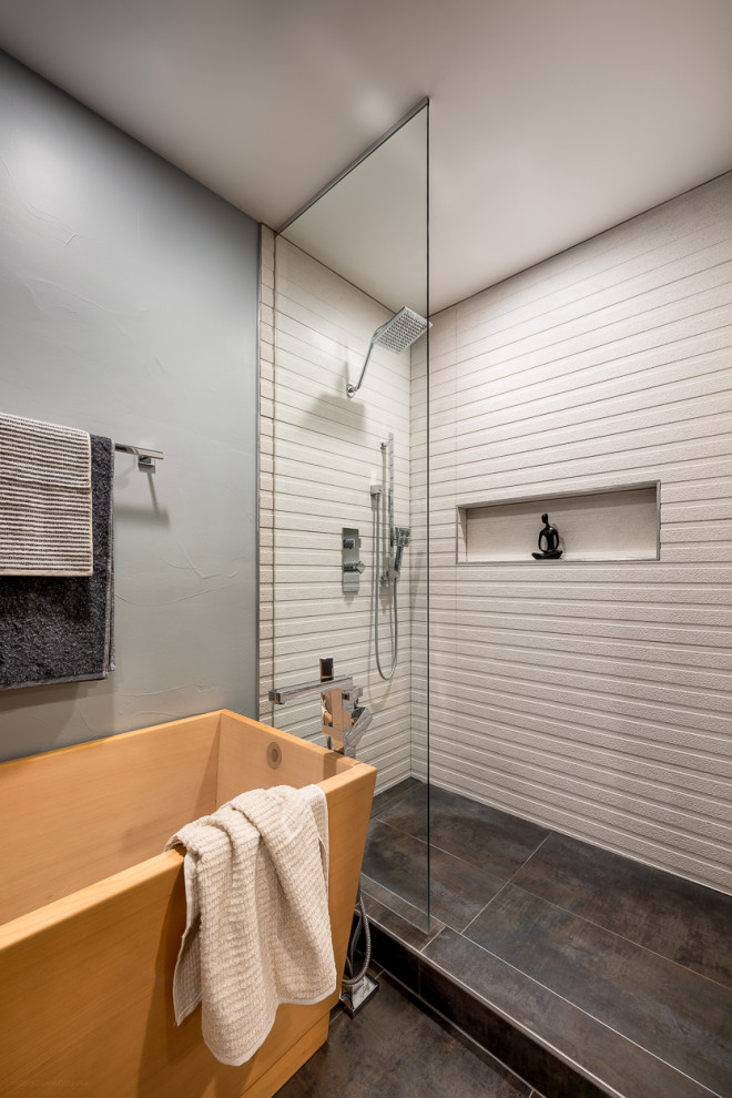 This is an example of a modern ensuite wet room bathroom in Denver with flat-panel cabinets, beige cabinets, a japanese bath, a one-piece toilet, blue walls, light hardwood flooring, a submerged sink, solid surface worktops, beige floors, an open shower and white worktops.