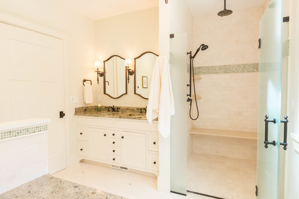Inspiration for a large timeless master beige tile and stone tile limestone floor alcove shower remodel in New York with furniture-like cabinets, white cabinets, an undermount tub, a two-piece toilet, beige walls, an undermount sink and granite countertops