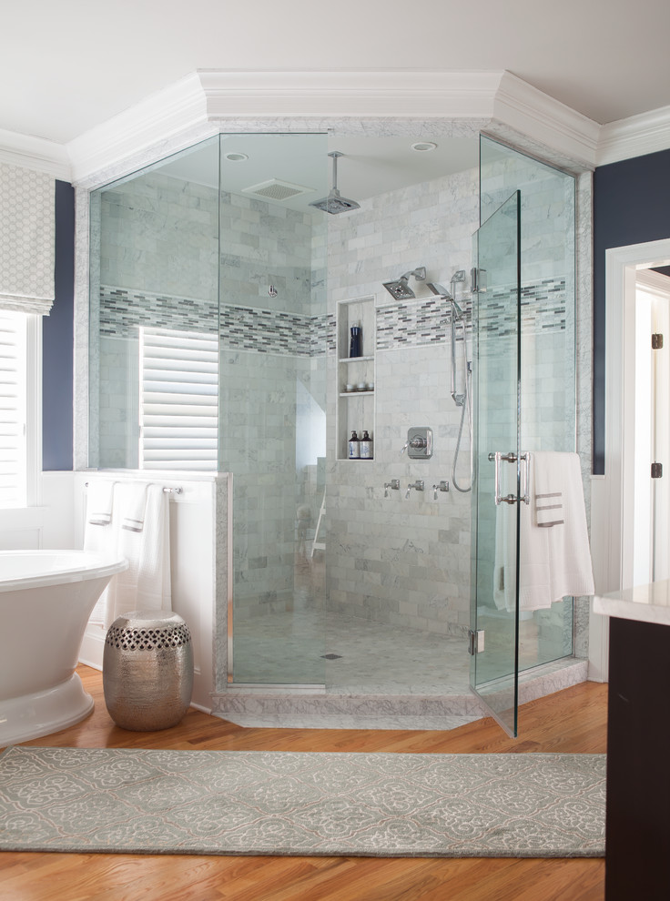 Bild på ett stort vintage en-suite badrum, med ett fristående badkar, vit kakel, blå väggar, mellanmörkt trägolv, en hörndusch och tunnelbanekakel