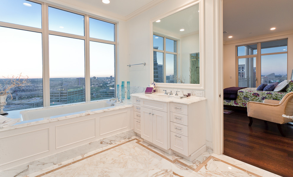 Klassisk inredning av ett en-suite badrum, med ett undermonterad handfat, luckor med upphöjd panel, vita skåp, ett undermonterat badkar och vita väggar