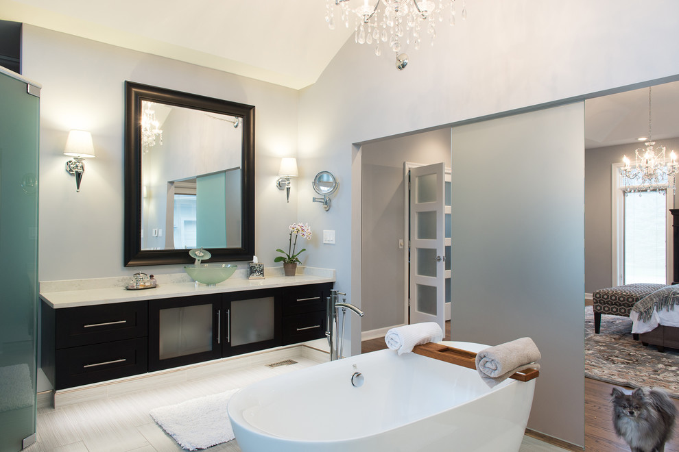 Exempel på ett stort modernt en-suite badrum, med luckor med glaspanel, skåp i mörkt trä, ett fristående badkar, en dubbeldusch, en bidé, grå kakel, kakel i småsten, grå väggar, klinkergolv i porslin, ett fristående handfat och bänkskiva i kvarts