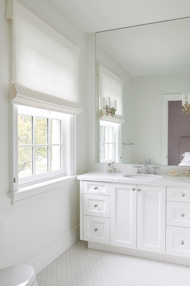 Пример оригинального дизайна: детская ванная комната среднего размера в классическом стиле с фасадами с утопленной филенкой, белыми фасадами, душем в нише, унитазом-моноблоком, белой плиткой, керамической плиткой, белыми стенами, полом из керамической плитки, подвесной раковиной, столешницей из искусственного кварца, белым полом, душем с распашными дверями и белой столешницей