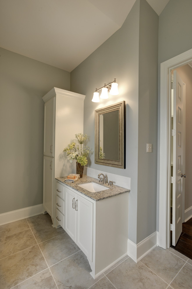 Bild på ett mellanstort vintage vit vitt en-suite badrum, med ett undermonterad handfat, luckor med infälld panel, vita skåp, granitbänkskiva, vit kakel, tunnelbanekakel, grå väggar, klinkergolv i keramik och beiget golv