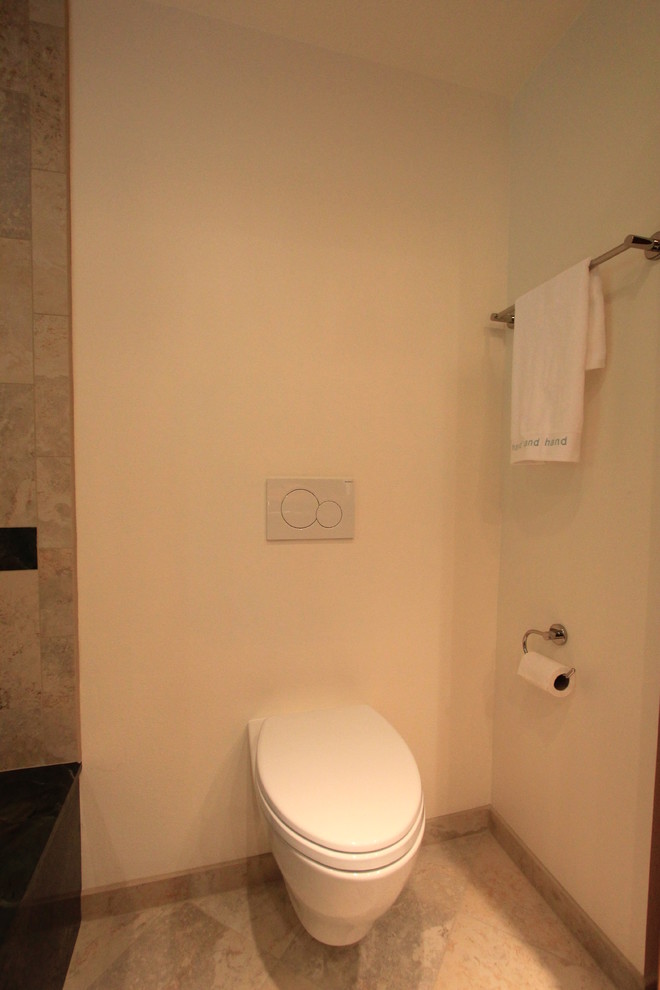 Idée de décoration pour un WC suspendu design en bois brun de taille moyenne avec un placard à porte plane, un carrelage marron, des carreaux de porcelaine, un mur blanc, un sol en carrelage de porcelaine, un lavabo encastré, un plan de toilette en granite et un sol gris.