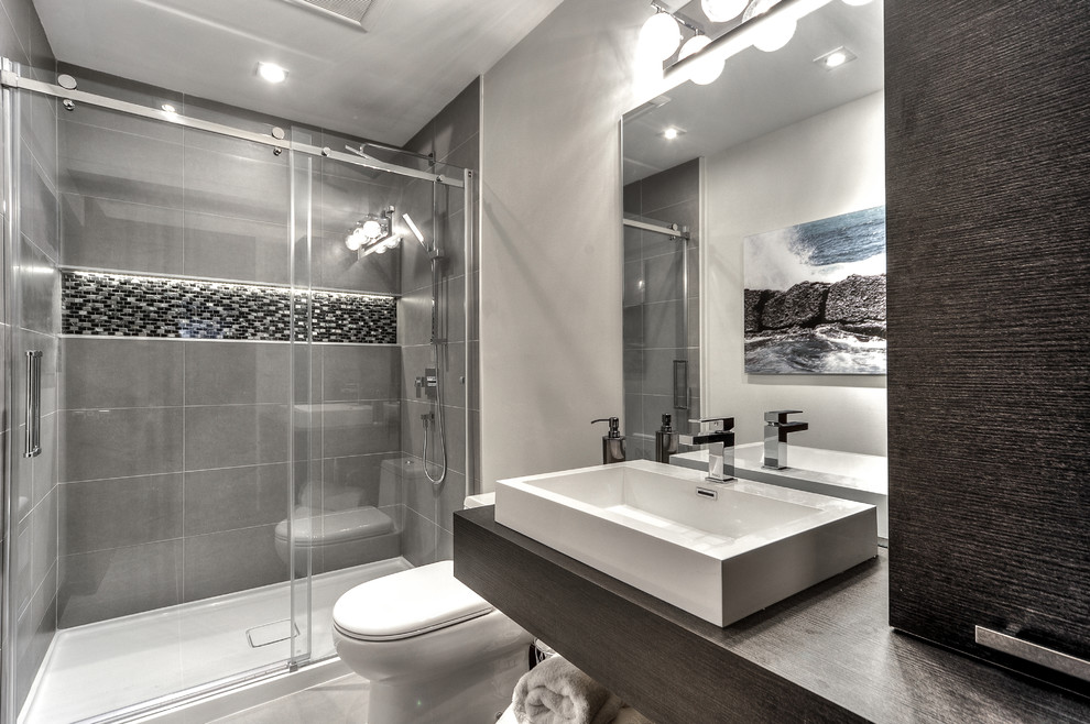 モントリオールにある高級な小さなコンテンポラリースタイルのおしゃれな浴室 (フラットパネル扉のキャビネット、ラミネートカウンター、アルコーブ型シャワー、グレーのタイル、セラミックタイル、グレーの壁、セラミックタイルの床、濃色木目調キャビネット) の写真