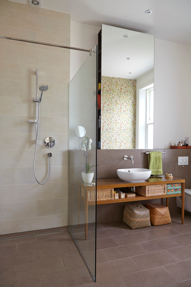 Inredning av ett modernt brun brunt badrum, med ett fristående handfat, öppna hyllor, skåp i mellenmörkt trä, träbänkskiva, en öppen dusch, en toalettstol med separat cisternkåpa, brun kakel, stenkakel, vita väggar, klinkergolv i keramik och med dusch som är öppen