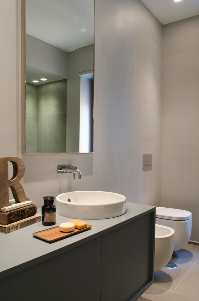 Пример оригинального дизайна: ванная комната в современном стиле с плоскими фасадами, серыми фасадами, инсталляцией, серыми стенами и настольной раковиной