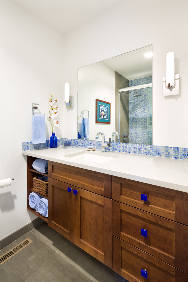 Modelo de cuarto de baño clásico renovado con armarios estilo shaker, puertas de armario de madera oscura, ducha empotrada, baldosas y/o azulejos azules, baldosas y/o azulejos en mosaico, aseo y ducha y lavabo bajoencimera