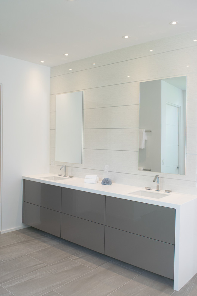 Exempel på ett stort modernt en-suite badrum, med släta luckor, grå skåp, ett fristående badkar, en toalettstol med hel cisternkåpa, vita väggar, ett integrerad handfat, en öppen dusch, vit kakel, glasskiva, laminatgolv, bänkskiva i akrylsten, beiget golv och med dusch som är öppen