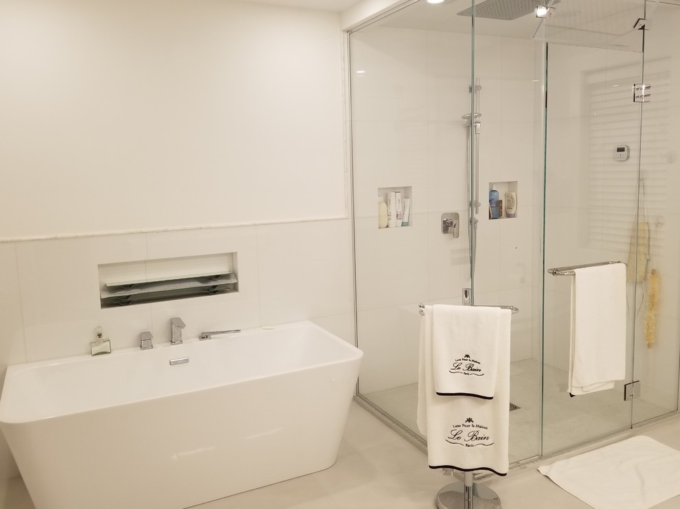 Idéer för mellanstora funkis badrum med dusch, med släta luckor, vita skåp, ett fristående badkar, en hörndusch, en vägghängd toalettstol, vit kakel, porslinskakel, vita väggar, betonggolv, ett integrerad handfat, bänkskiva i akrylsten, grått golv och dusch med gångjärnsdörr