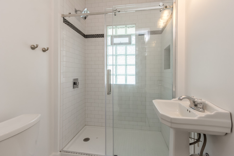 Modelo de cuarto de baño contemporáneo pequeño con ducha abierta, sanitario de dos piezas, paredes blancas, suelo con mosaicos de baldosas, aseo y ducha, lavabo con pedestal, suelo azul y ducha con puerta corredera