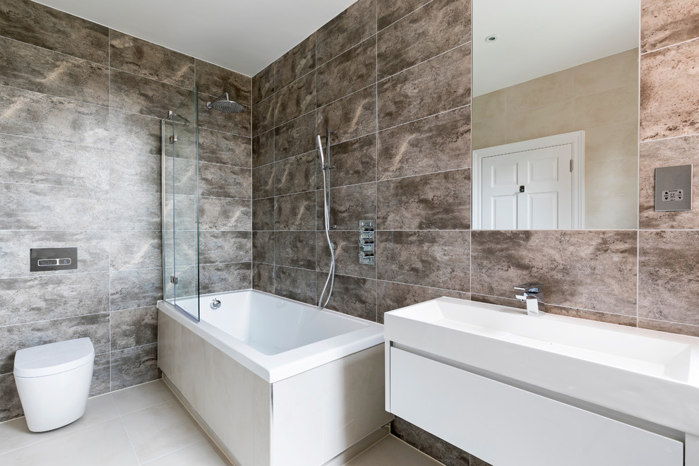 На фото: большая главная ванная комната в современном стиле с плоскими фасадами, белыми фасадами, угловой ванной, душем над ванной, унитазом-моноблоком, разноцветными стенами, серым полом и душем с раздвижными дверями