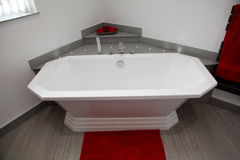 Пример оригинального дизайна: ванная комната среднего размера в современном стиле с плоскими фасадами, серыми фасадами, отдельно стоящей ванной, открытым душем, унитазом-моноблоком, красными стенами, душевой кабиной, настольной раковиной, столешницей из искусственного камня, серым полом, открытым душем и серой столешницей