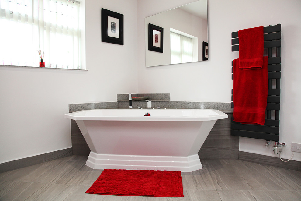 Идея дизайна: ванная комната среднего размера в современном стиле с плоскими фасадами, серыми фасадами, отдельно стоящей ванной, открытым душем, унитазом-моноблоком, красными стенами, душевой кабиной, настольной раковиной, столешницей из искусственного камня, серым полом, открытым душем и серой столешницей