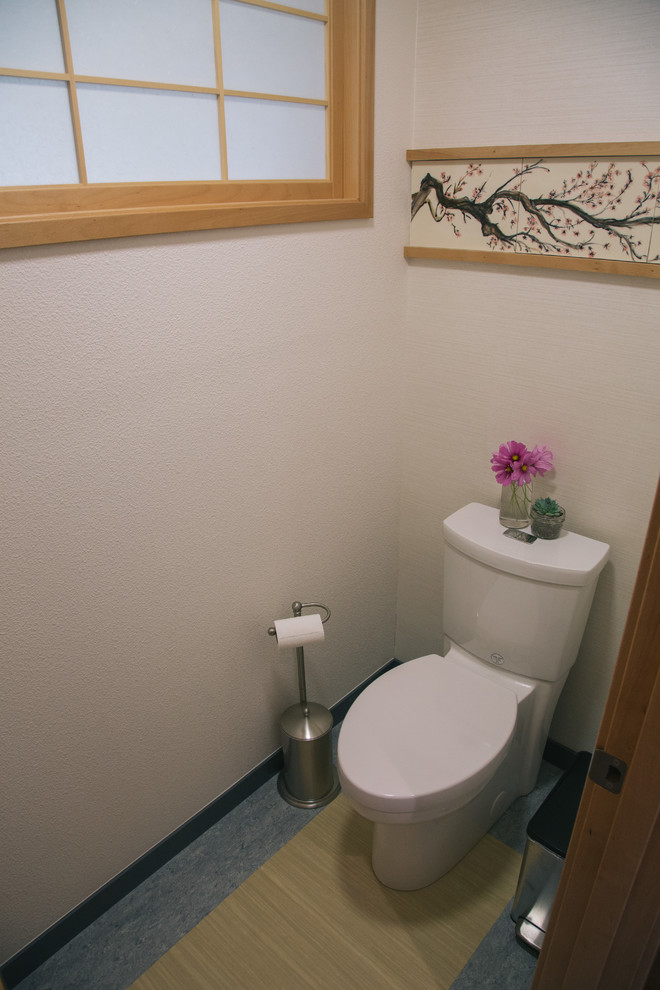 Exempel på ett stort asiatiskt toalett, med släta luckor, skåp i ljust trä, en toalettstol med hel cisternkåpa, svart kakel, keramikplattor, vita väggar, linoleumgolv, ett fristående handfat och marmorbänkskiva