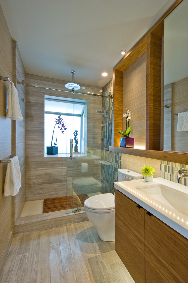 Modernes Badezimmer mit Unterbauwaschbecken, flächenbündigen Schrankfronten, Quarzwerkstein-Waschtisch, offener Dusche, Toilette mit Aufsatzspülkasten, blauen Fliesen, Mosaikfliesen und Kalkstein in Hawaii
