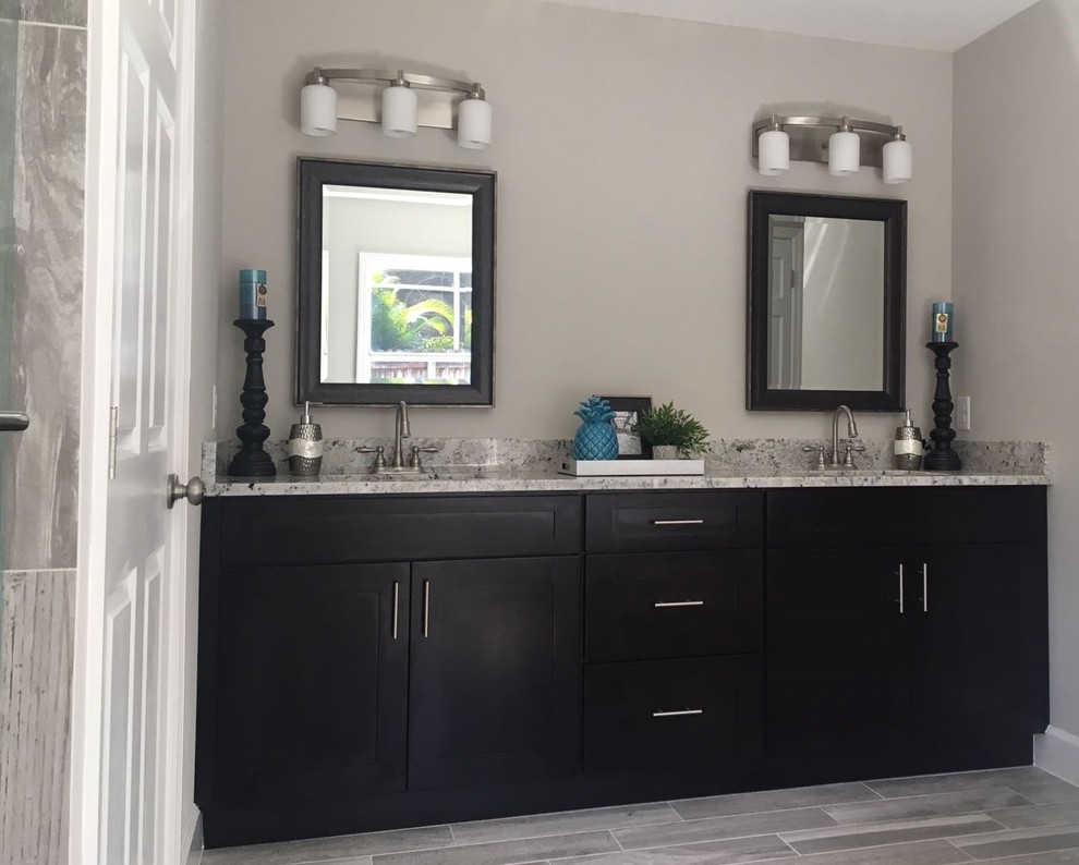 Example of a mid-sized transitional master porcelain tile and gray floor bathroom design in Orlando with shaker cabinets, black cabinets, gray walls and granite countertops