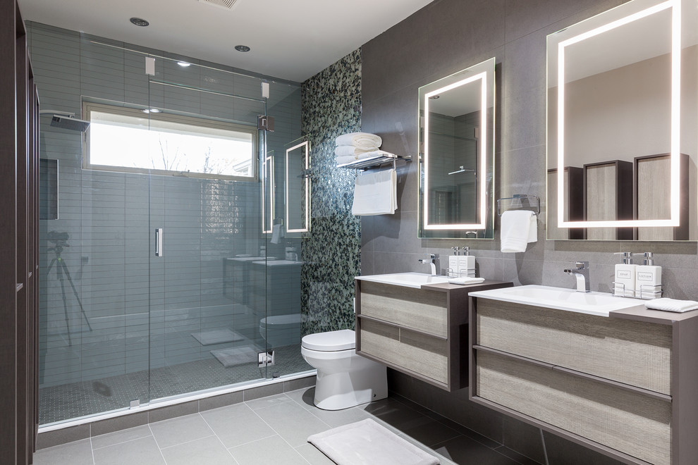 Design ideas for a medium sized contemporary ensuite bathroom in Dallas with flat-panel cabinets, grey cabinets, an alcove shower, a one-piece toilet, grey tiles, white tiles, pebble tiles, grey walls, porcelain flooring, a built-in sink and concrete worktops.