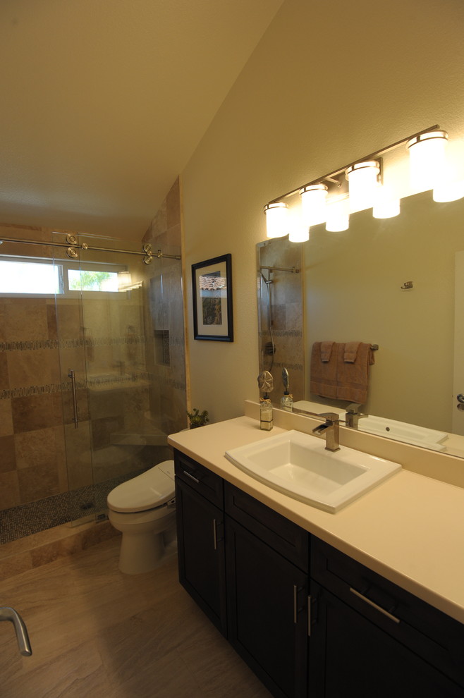 Diseño de cuarto de baño contemporáneo de tamaño medio con lavabo encastrado, armarios estilo shaker, puertas de armario de madera en tonos medios, encimera de cuarzo compacto, bidé, baldosas y/o azulejos beige, losas de piedra y suelo de travertino