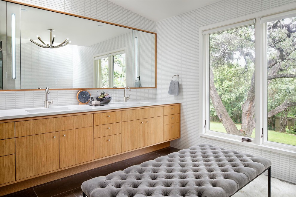 Cette photo montre une salle de bain tendance en bois brun avec un lavabo encastré, un placard à porte plane et un carrelage blanc.