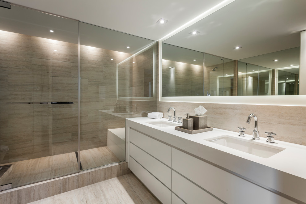 Exemple d'une douche en alcôve principale tendance avec un placard à porte plane, des portes de placard blanches, un carrelage beige, un lavabo encastré et un sol beige.
