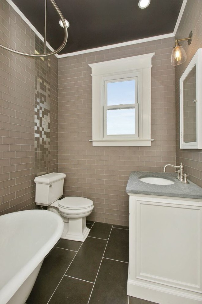 Photo of a small contemporary family bathroom in San Francisco with recessed-panel cabinets, white cabinets, a claw-foot bath, a shower/bath combination, a one-piece toilet, beige tiles, ceramic tiles, beige walls, ceramic flooring, a submerged sink and limestone worktops.