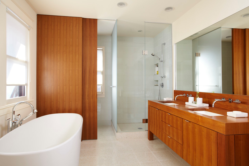 Пример оригинального дизайна: главная ванная комната среднего размера в современном стиле с врезной раковиной, плоскими фасадами, фасадами цвета дерева среднего тона, столешницей из дерева, отдельно стоящей ванной, угловым душем и белыми стенами