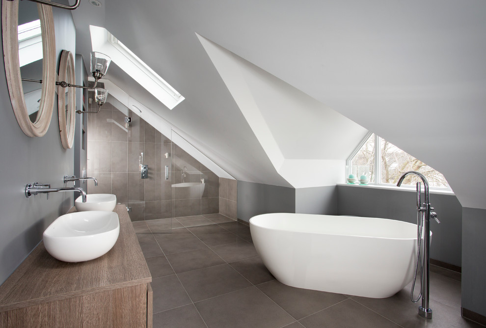 ロンドンにあるコンテンポラリースタイルのおしゃれなマスターバスルーム (ベッセル式洗面器、置き型浴槽、グレーの壁、茶色い床) の写真