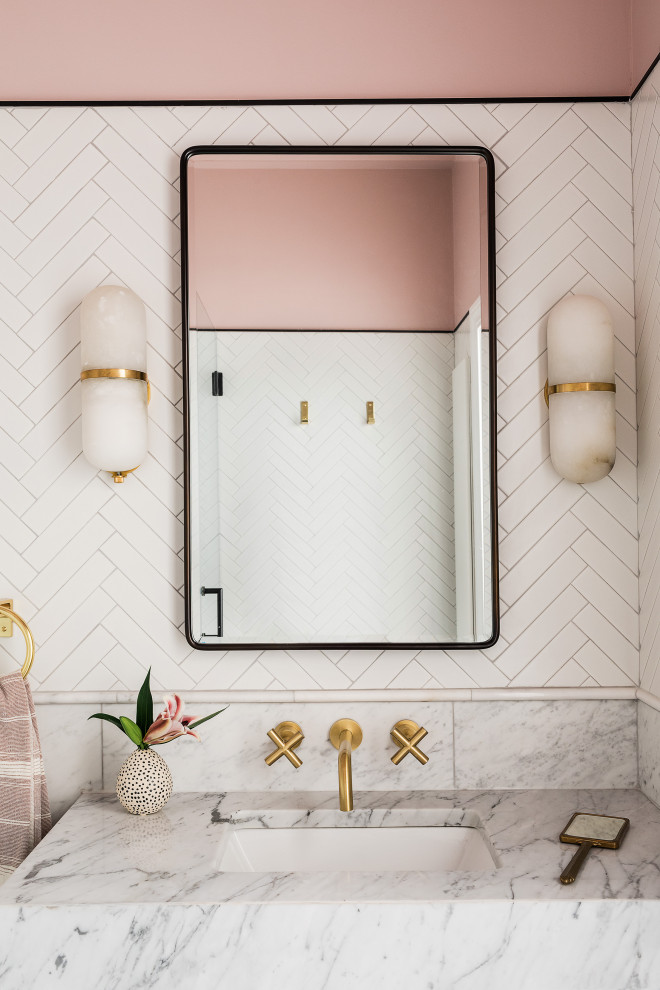 Foto de cuarto de baño contemporáneo de tamaño medio con armarios con paneles lisos, puertas de armario grises, baldosas y/o azulejos blancos, paredes rosas, aseo y ducha, lavabo bajoencimera y encimeras grises