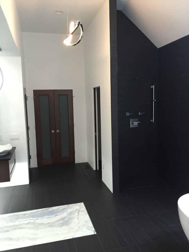 This is an example of a contemporary bathroom in Other with dark wood cabinets, a freestanding bath, a built-in shower, black and white tiles, ceramic tiles, white walls, porcelain flooring, a wall-mounted sink and onyx worktops.