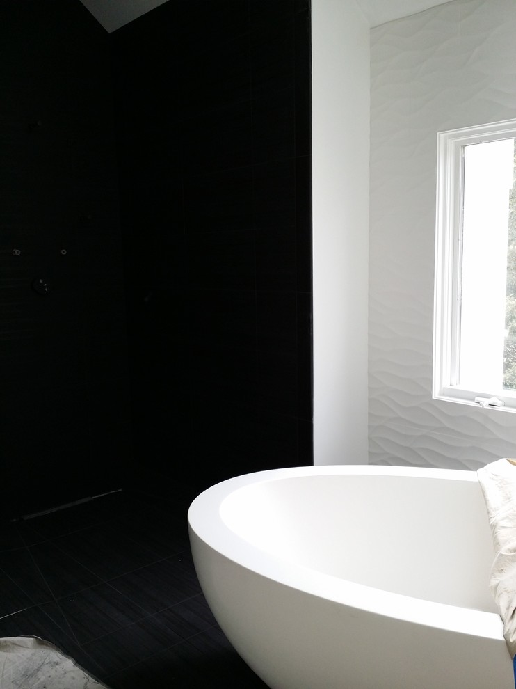 Bild på ett funkis badrum, med skåp i mörkt trä, ett fristående badkar, en kantlös dusch, svart och vit kakel, keramikplattor, vita väggar, klinkergolv i porslin, ett väggmonterat handfat och bänkskiva i onyx