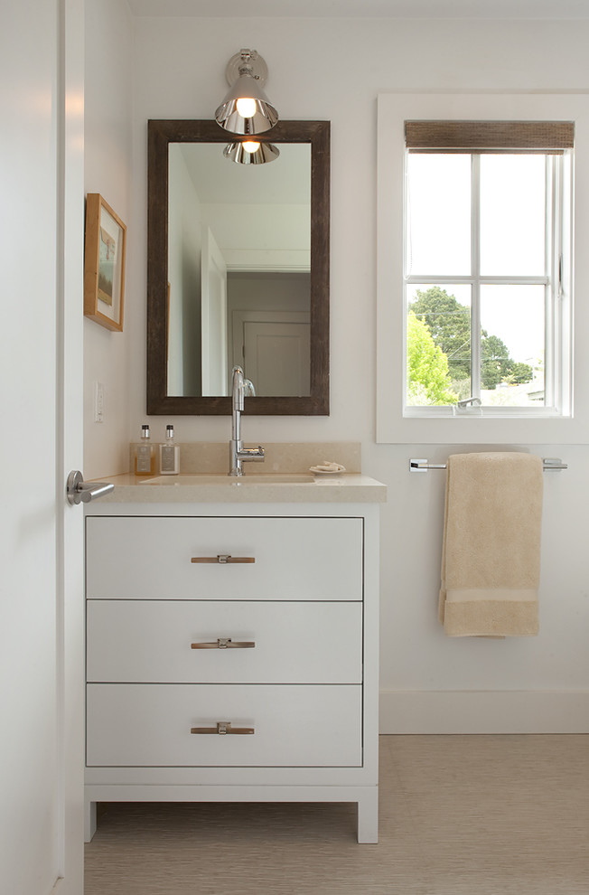Immagine di una stanza da bagno minimal con lavabo sottopiano, ante lisce e ante bianche