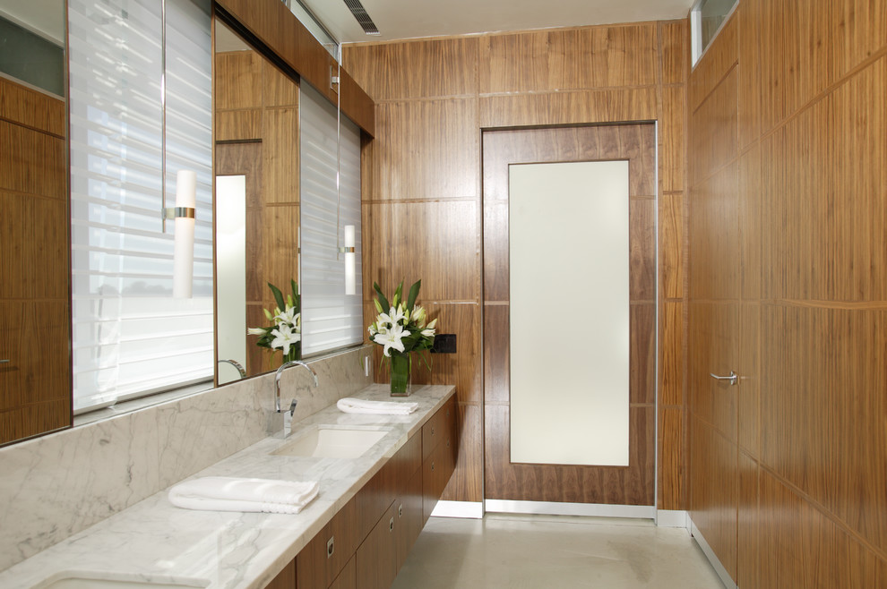 Réalisation d'une salle de bain design avec un plan de toilette en marbre.