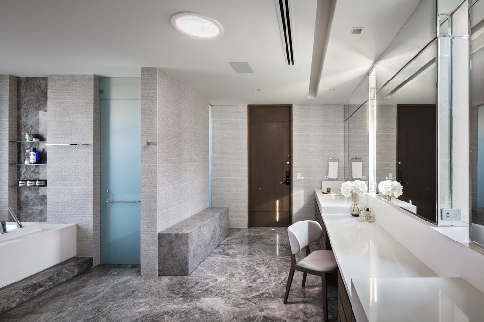 Ejemplo de cuarto de baño principal contemporáneo con bañera encastrada, paredes grises, lavabo bajoencimera, suelo gris y encimeras blancas