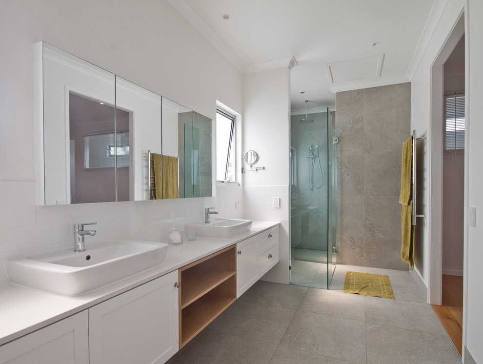Medium sized contemporary ensuite bathroom in Sunshine Coast with a vessel sink, shaker cabinets, white cabinets, engineered stone worktops, a double shower, a wall mounted toilet, grey tiles, porcelain tiles, white walls and porcelain flooring.
