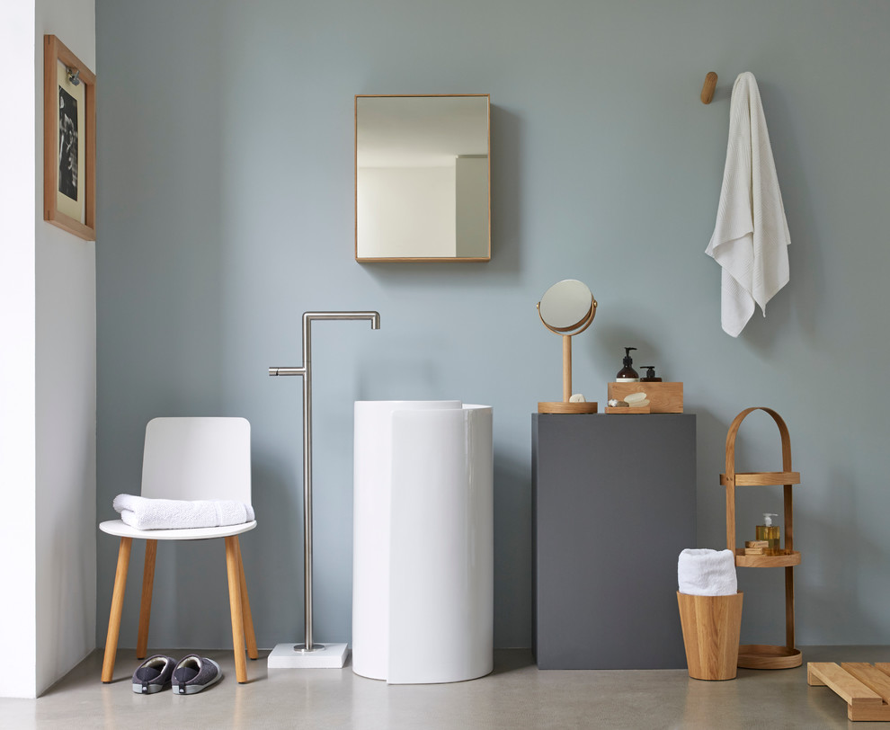 Skandinavisches Badezimmer mit offenen Schränken, hellbraunen Holzschränken, grauer Wandfarbe, Betonboden und Sockelwaschbecken in London
