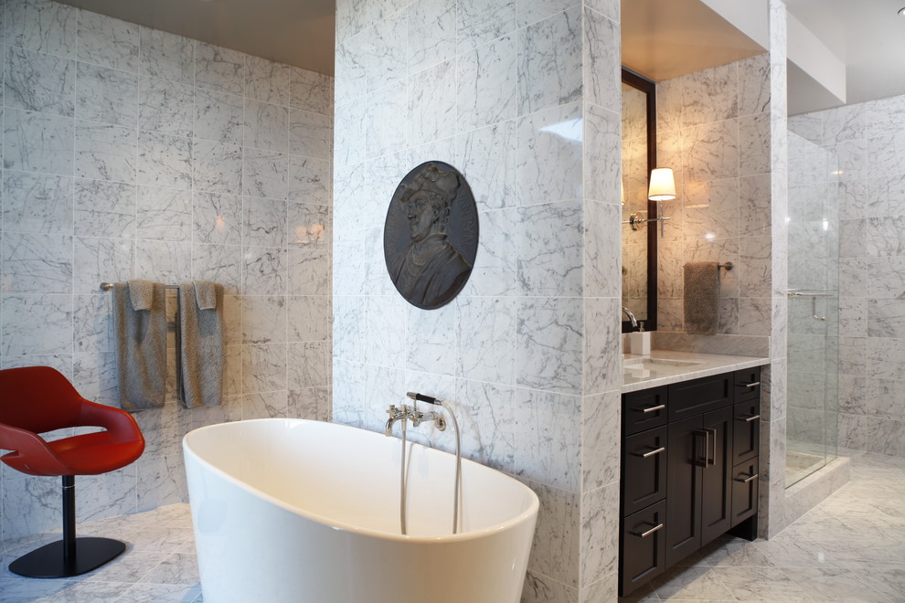 Photo of a contemporary bathroom in Austin with a freestanding bath and marble tiles.